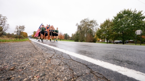 Army ROTC Cadets from MSU and UofM running in rain on a back country road